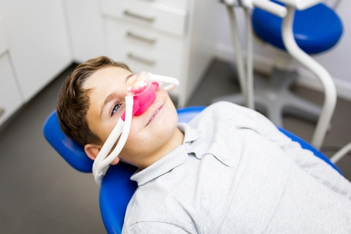 a little boy receiving laughing gas