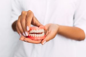 woman holding dentures