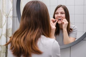 young girl putting in invisalign aligners