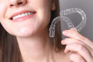woman holding invisalign aligners