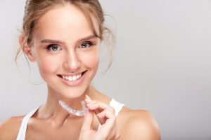 woman holding clear aligners
